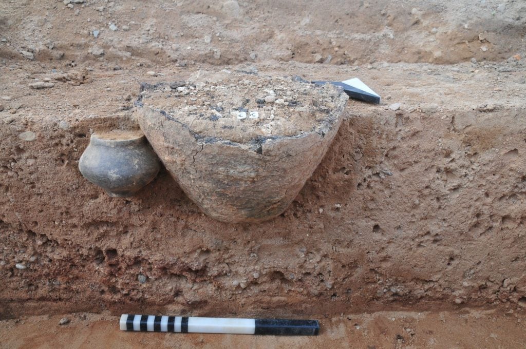 An ancient urn protruding from a stone ledge