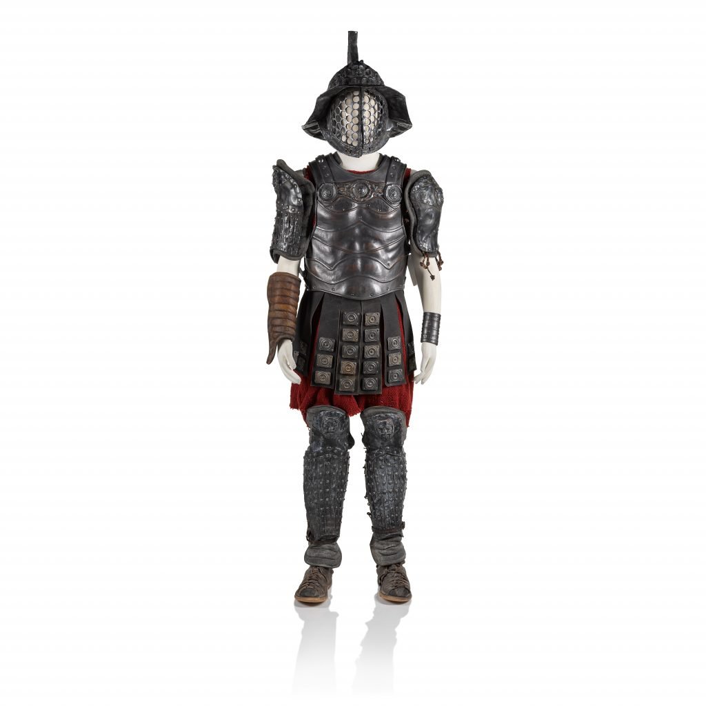 A photograph of a full, standing set of gladiator armor, on a white background