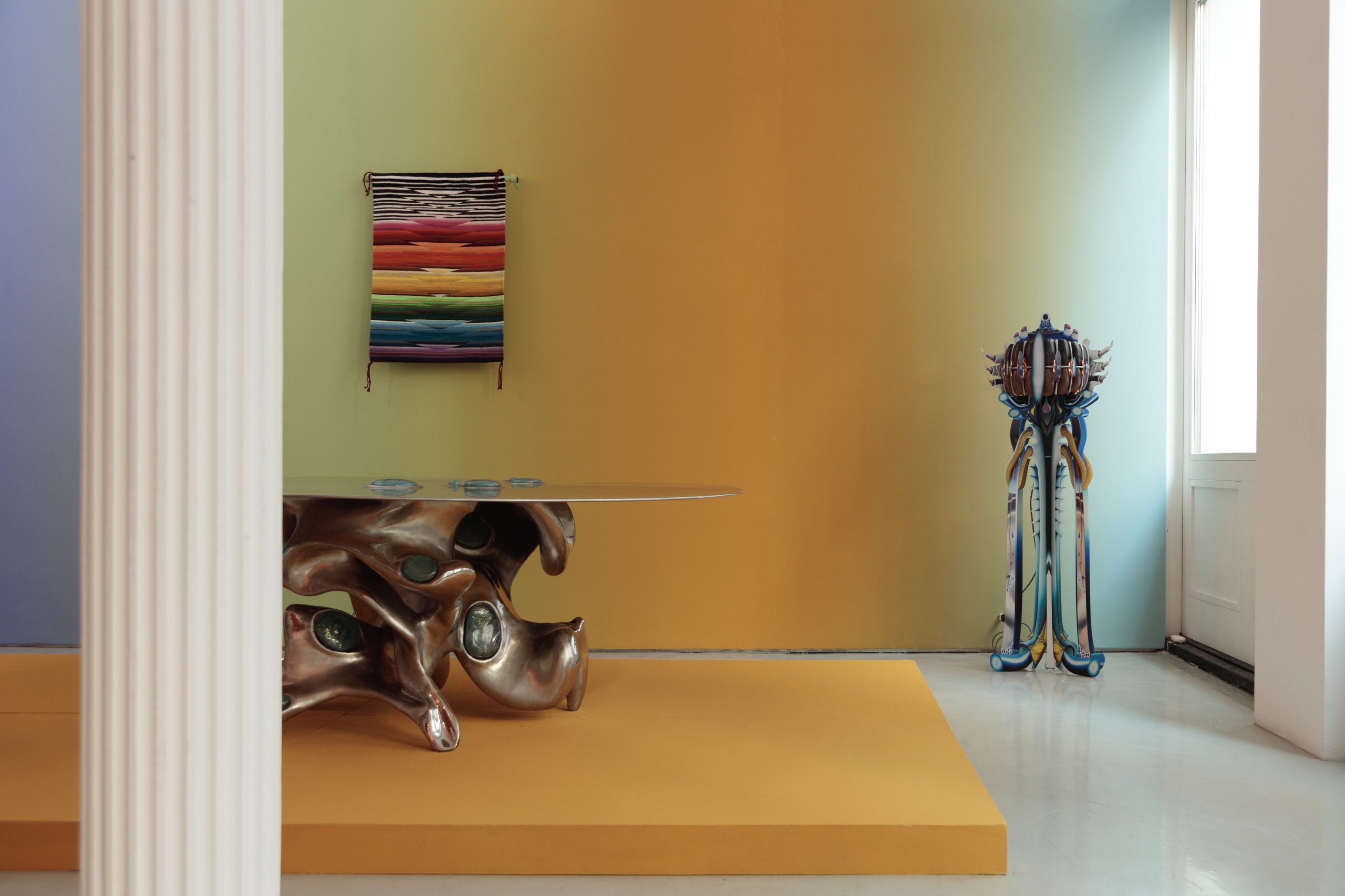 a design gallery has ombre walls and a yellow background and high concept furniture with a Native American futurist flair