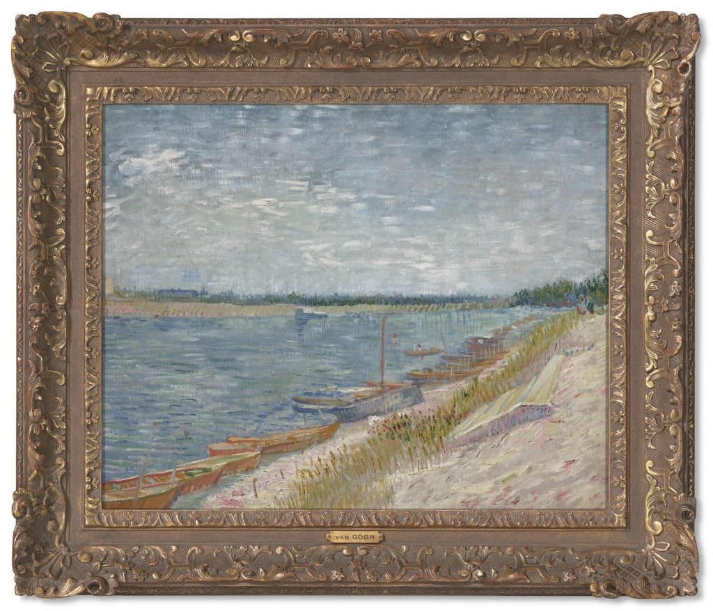 This image shows a framed painting of a river side with boats parked by the shore