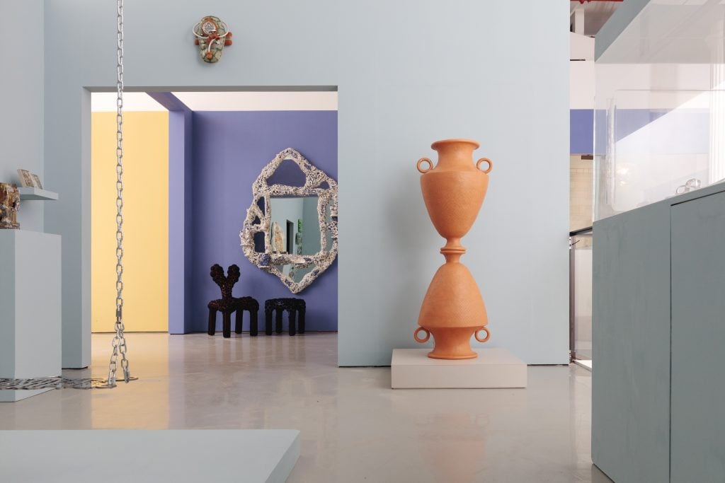 a design gallery has modern objects like a swing for adults and vases and amorphsc mirrors