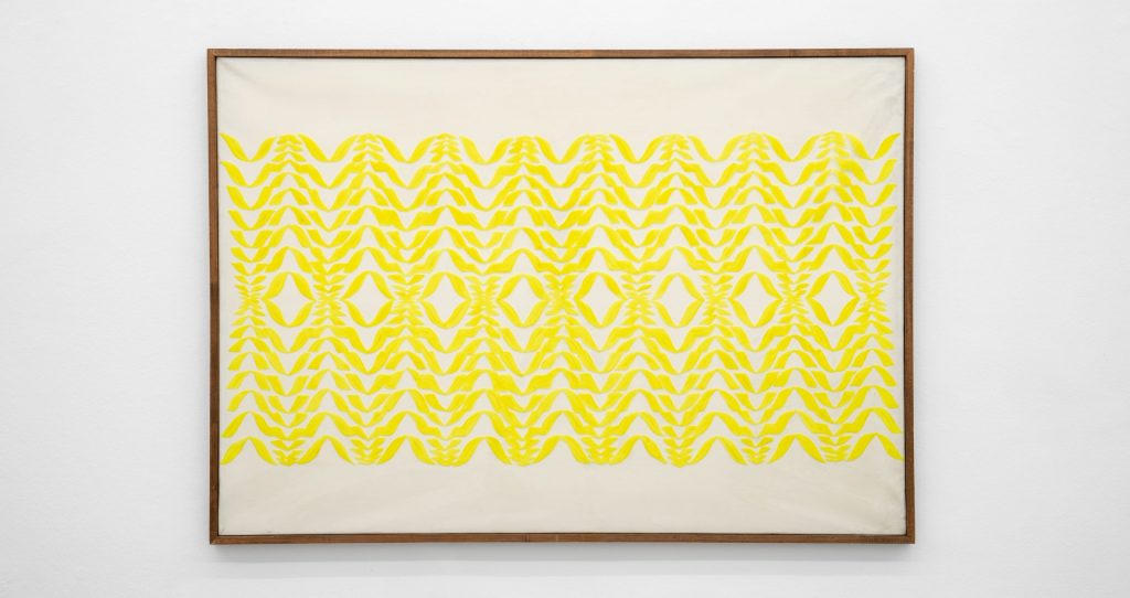 a yellow abstracted fiber work depicts limbs 