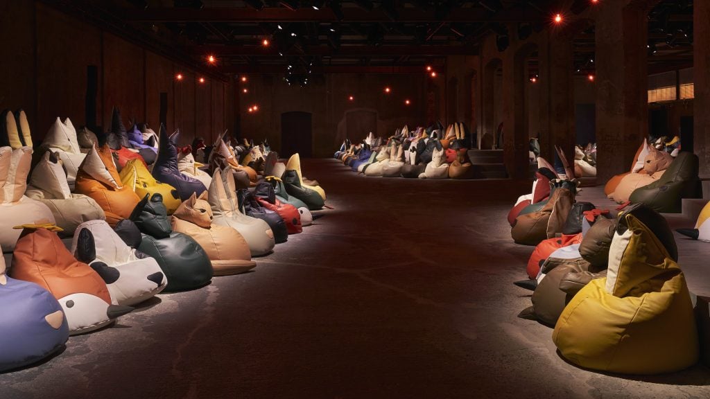 a fashion runway for Bottega Veneta is decorated with beanbag chairs that look like animals 