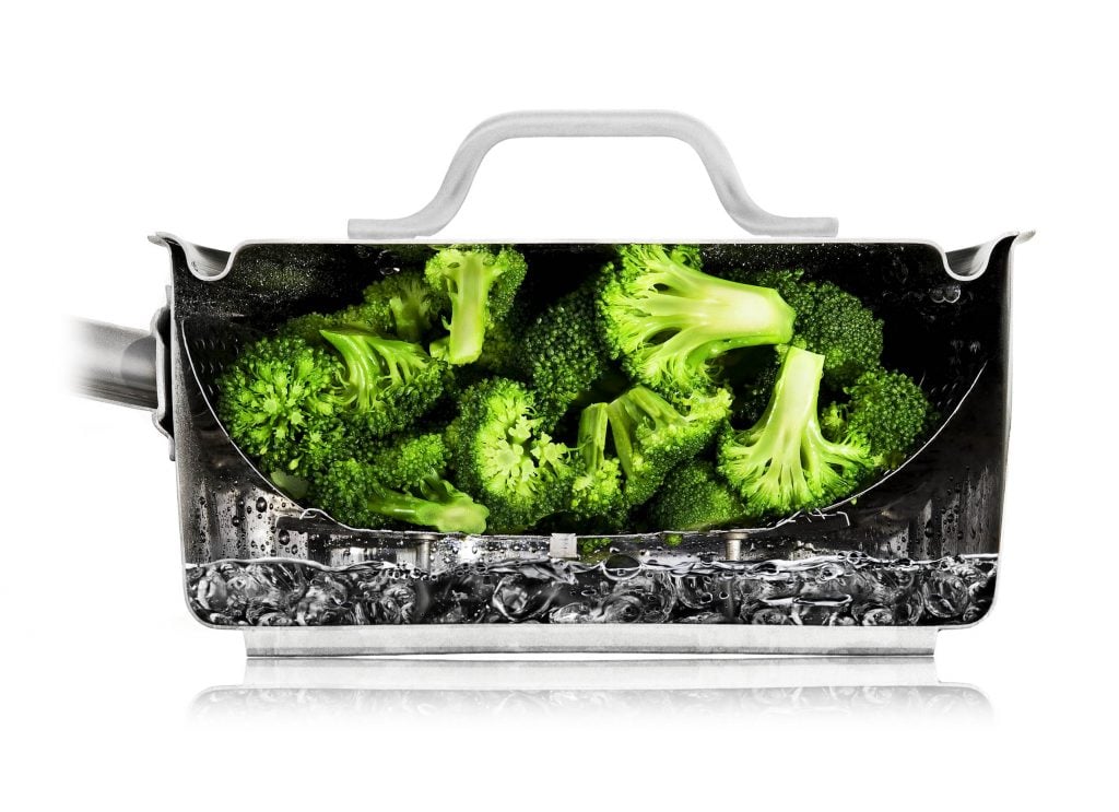 A photo of broccoli from Nathan Myhrvold's Modernist Cuisine: The Art and Science of Cooking (2011) steaming inside a pot that has been sliced in half to show a cross section.