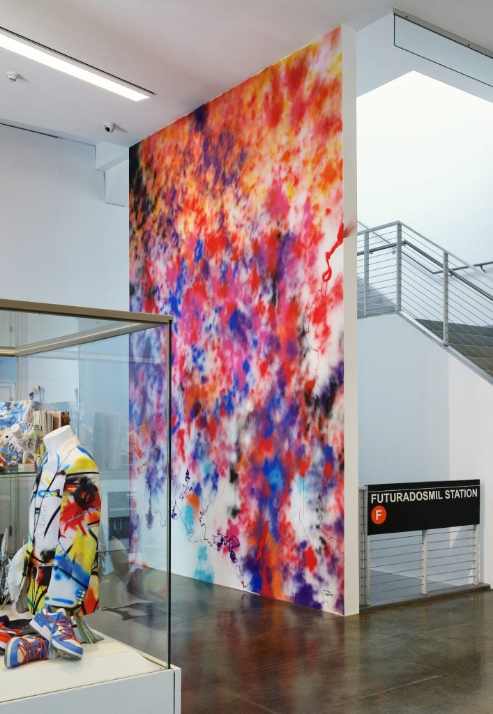 Futura 2000 made a site-specific mural for his show at the Bronx Museum. A wall in front of a stairwell is painted in colorful bursts of spray paint. 