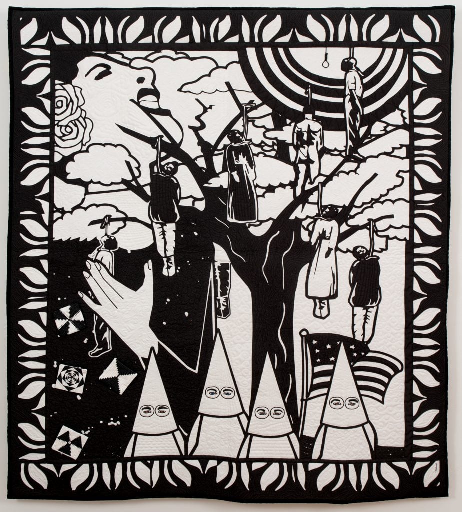 Carolyn Mazloomi, Strange Fruit #3. A black and white art quilt of singer Billie Holiday juxtaposed with a tree where seven African Americans have been lynched, with four hooded Ku Klux Klansmen. 