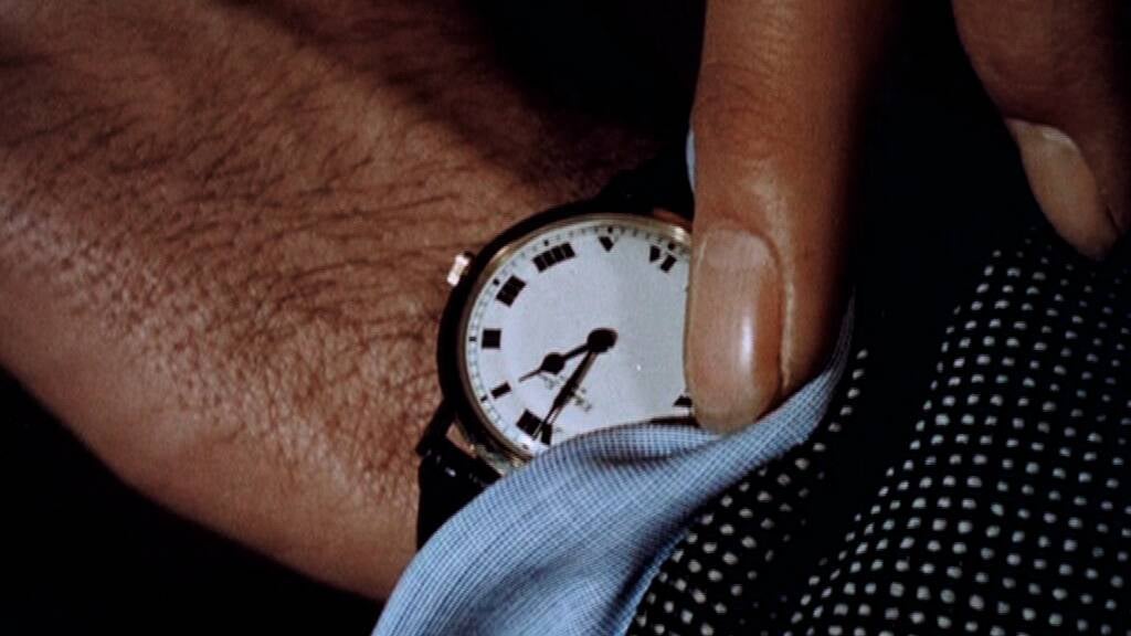 A still from Christian Marclay's "The Clock" featuring a man's wrist as he checks the time on his watch.