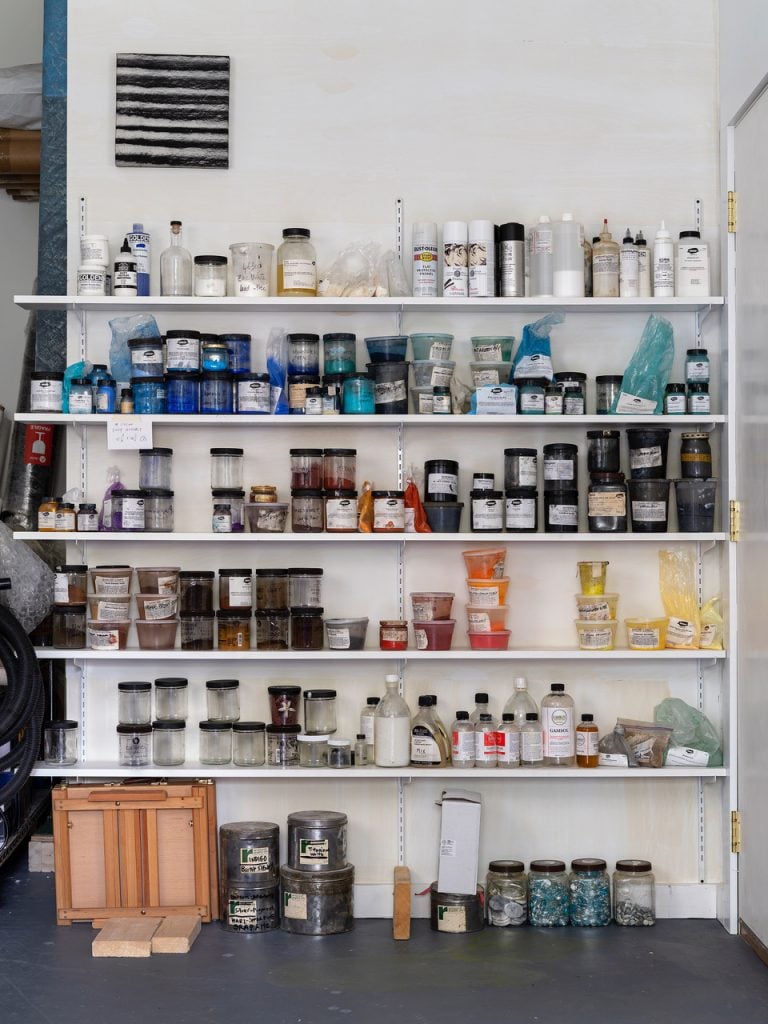 shelves of solvents and pigments in an artist studio