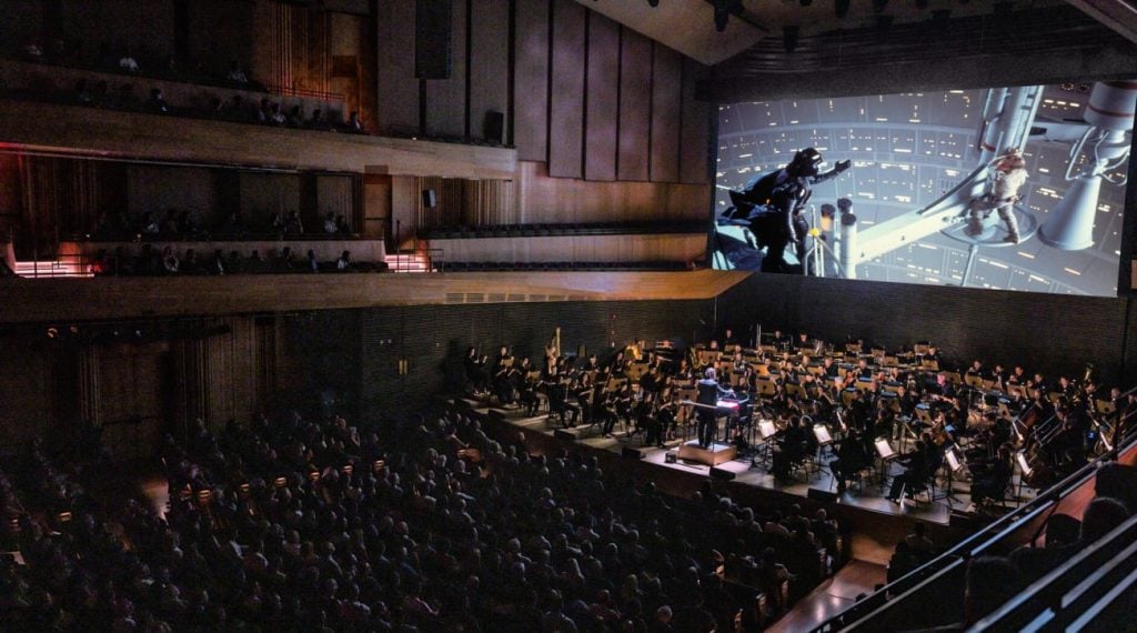 a large theater has a film and orchestra 