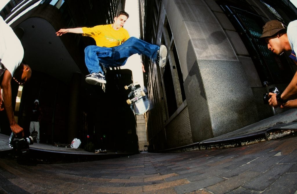 a night scene with a person midair doing a skateboarding trick