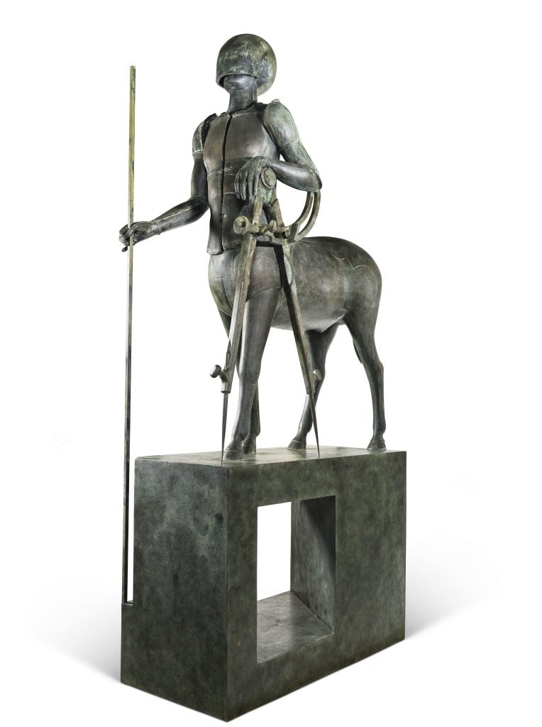 Lalanne's brass sculpture of a centaur atop a podium. the centaur is armored and helmed, wielding a staff in on hand and a giant drawing compass in the other.