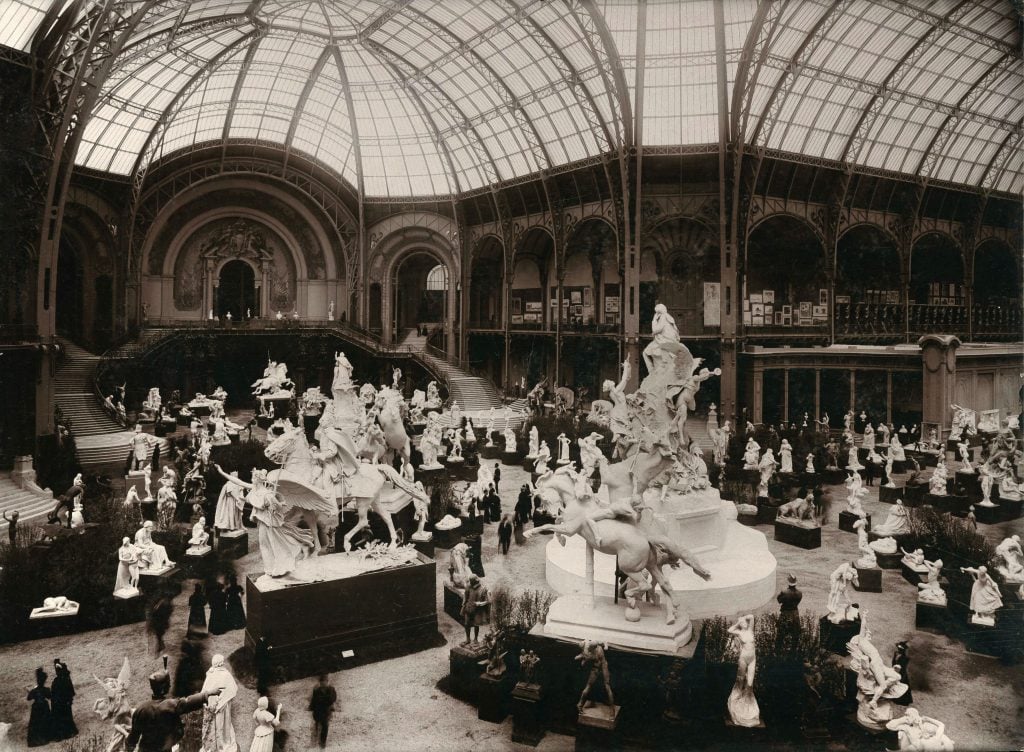 a black and white photo of a 1900 sculpture exhibition in the enthralling grand Palais domed interior 