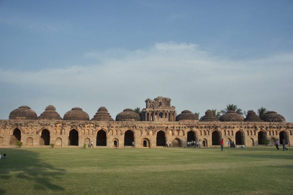 the royal elephant stable at Hampi is a structure featuring a row of 11 domed stables in a vast green courtyard