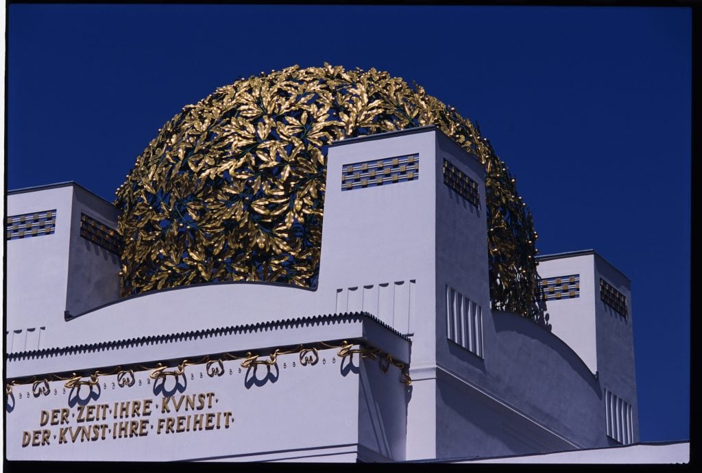 a gold leaf dome on a white building