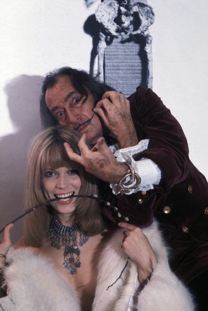 Amanda Lear and Salvador Dali huddle together for a photograph