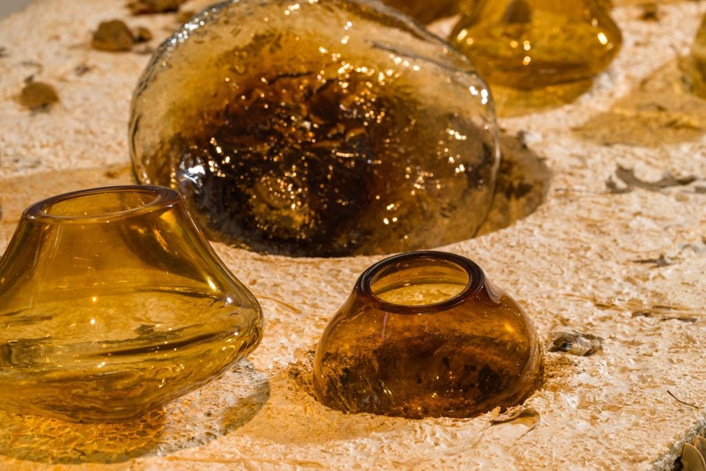 close up shots of handblown glass vessels atop a table 