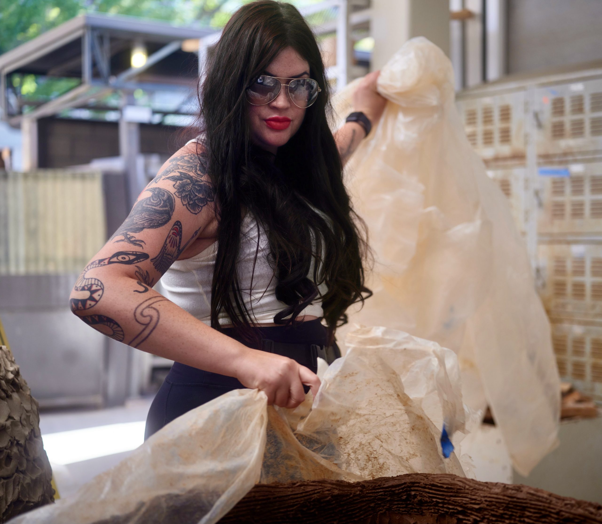 a photo of a woman with long dark hair and tattoos