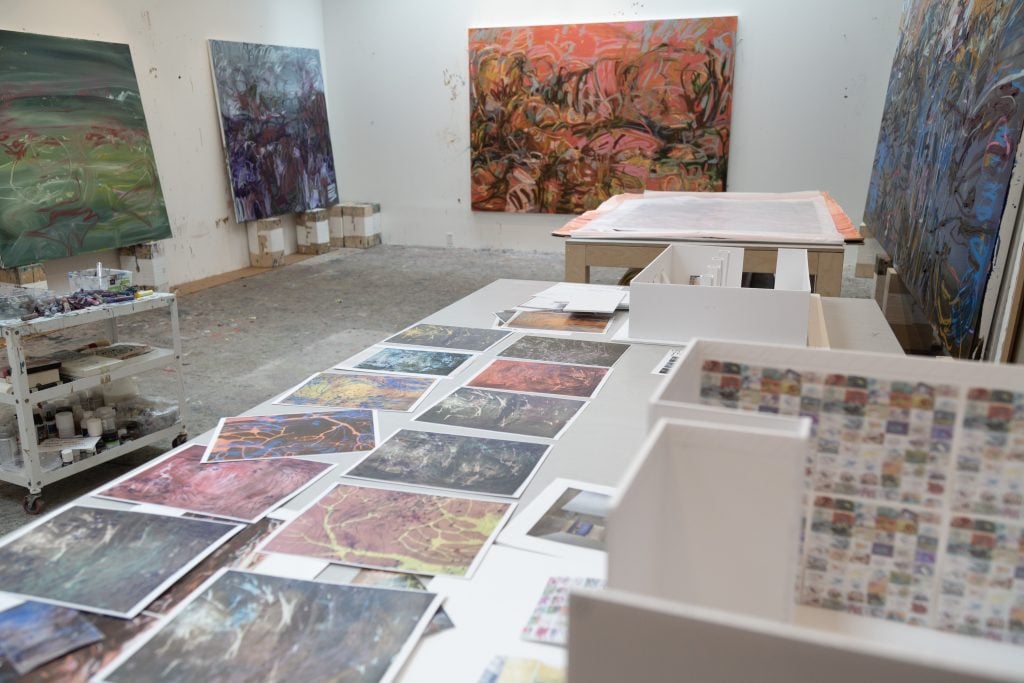 artworks lining a table in an artist's studio