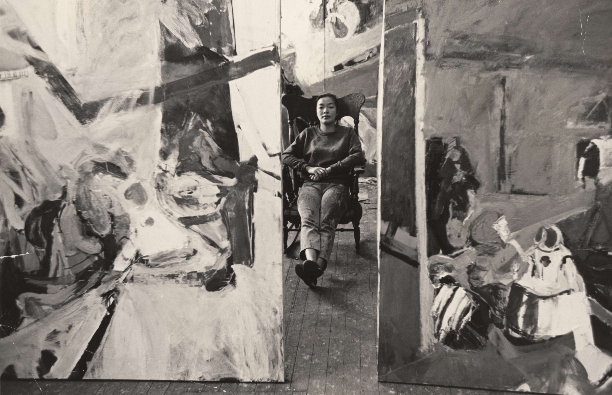 a black-and-white photograph of a young woman in an art studio