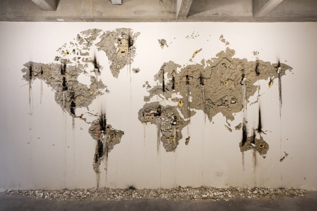 a map of the world is carved into a white wall