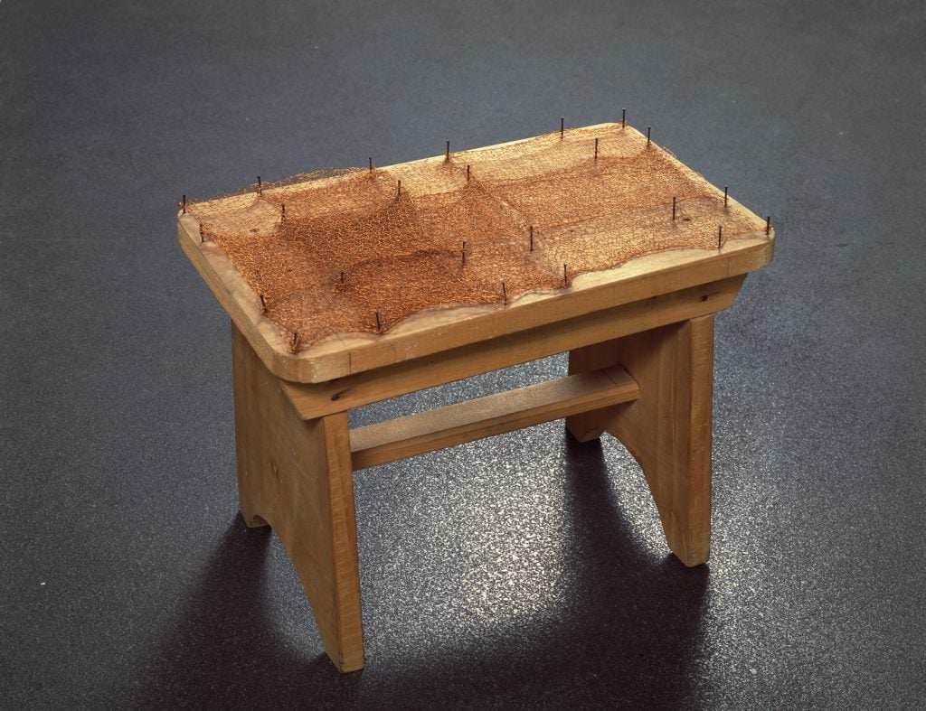 artwork that is a wooden stool with woven copper on the seat