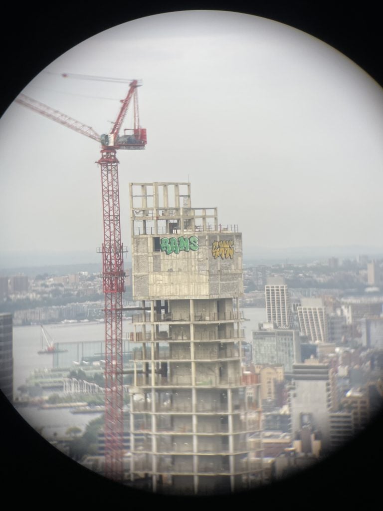 RAMS graffiti on 45 Park Place in New York, photographed through binoculars from an office building.