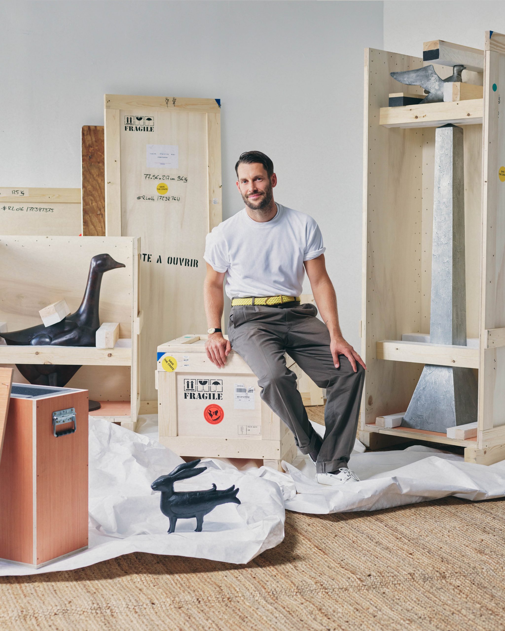 a portrait of Simon Porte Jacquemus surrounded by sculptures by Lalanne