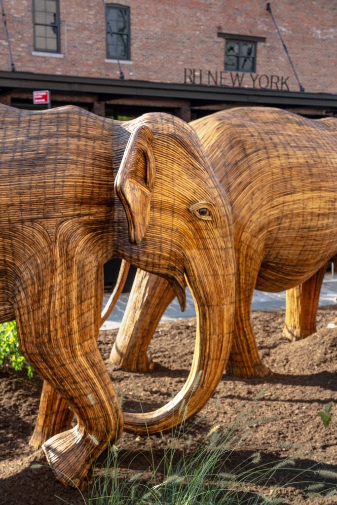 "The Great Elephant Migration" in New York's Meatpacking District. A close up shot of two life-size wooden elephant sculptures.