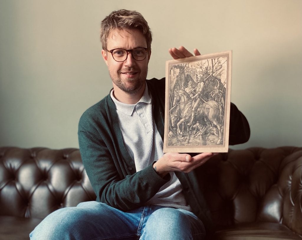 an image of Mat Winter holding the Durer engraving he saved from a rubbish dump years ago