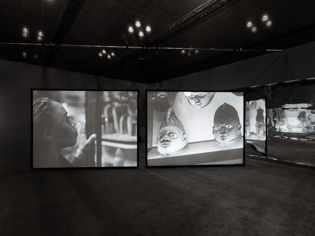 two screens show art films at a gallery 