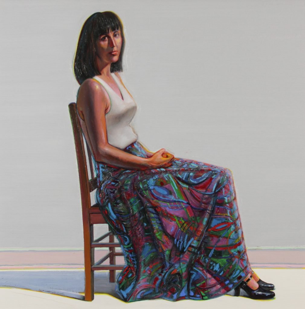 Wayne Thiebaud, Tapestry Skirt. A young woman with dark, shoulder-length hair sits in profile in a wooden lattice back chair. She is wearing a sleeveless white top and a full, patterned skirt. The painting looks like a more contemporary version of the famous canvas Whistler's Mother.