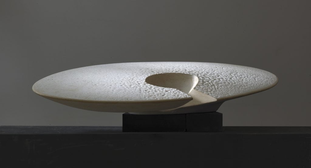 A white sinai limestone disk with whole in the center by artist Yves Dana, included in the inaugural exhibition at L'Appartement.