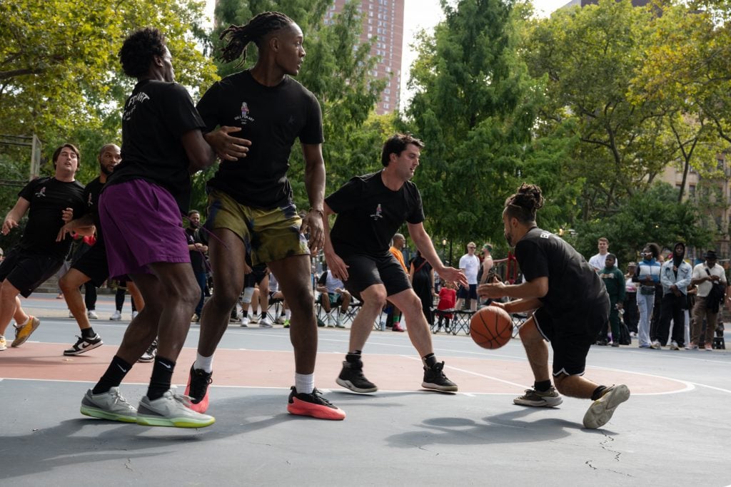 A photograph of an outdoor basketball game in action.