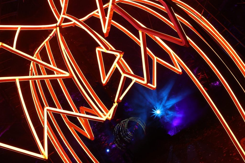 A pumpkin with an illuminated outline in a park