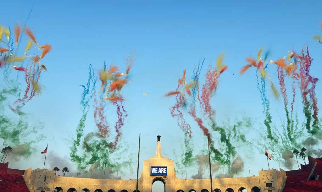 A series of colorful fireworks, designed by Cai Guo-Qiang, shooting skyward.