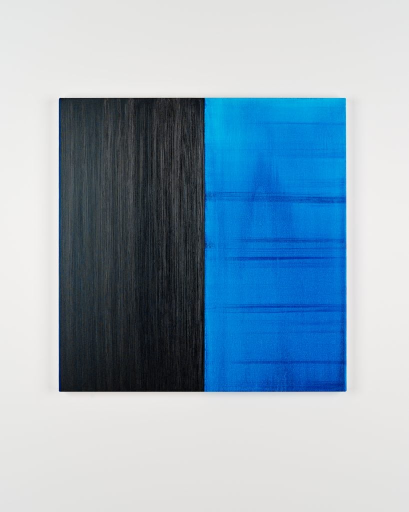 Square painting by Callum Inness split in two halves, the right in black with textured vertical brushstrokes the length of the canvas, and on the right blue that is semi-translusent with vertical and horizontal brushstrokes visible.