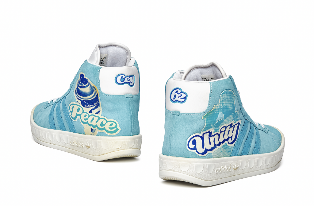 A photo of a pair of light blue high top sneakers by Cey Adams that read unity on side, seen from the back.