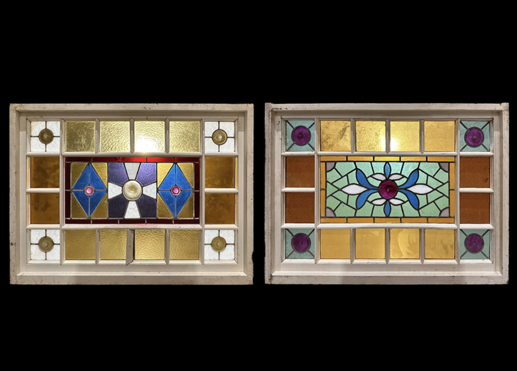 A photograph of two colorful stained glass window fixtures from the Chelsea Hotel, pictured side by side on an all-black background.