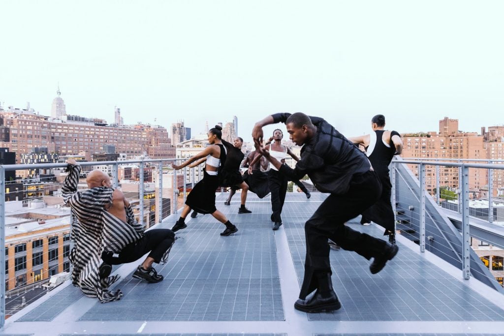 A group of dancers pose on a roof deck