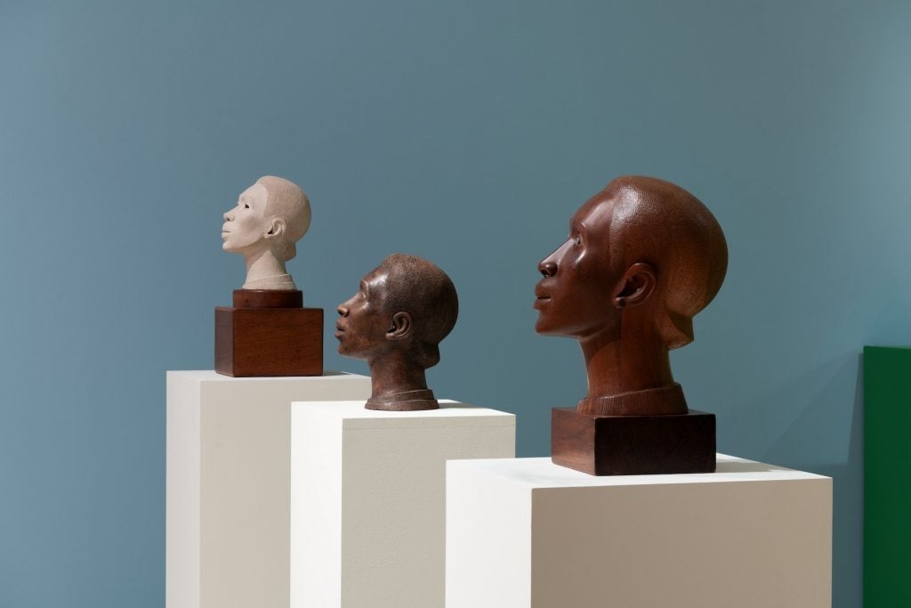 Three sculptures of heads in profile