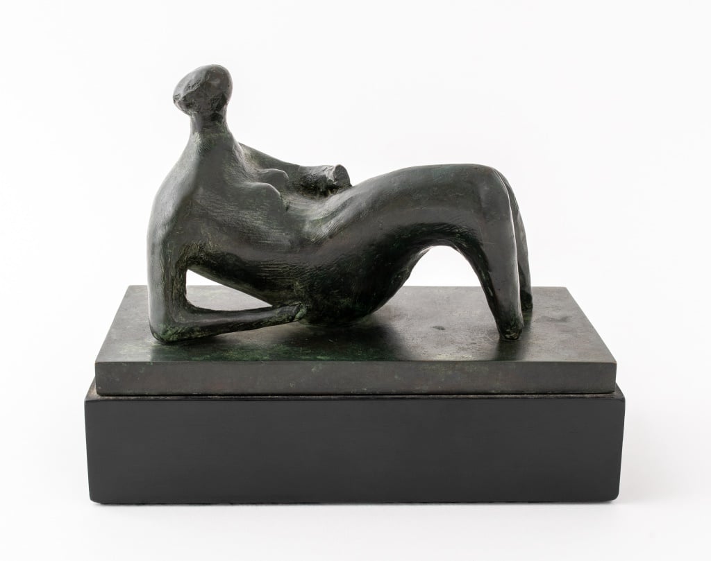 A bronze sculpture of an abstracted figure reclining by Henry Moore. Presented by Showplace from their top auction lots.