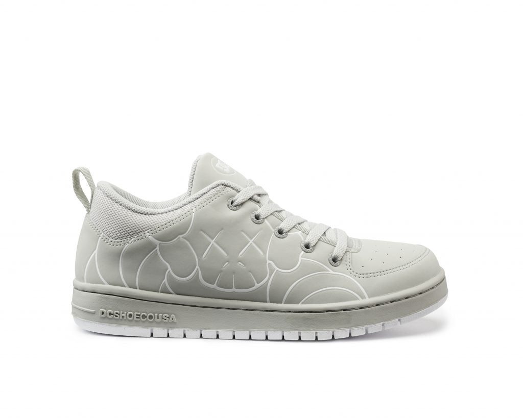 A photo of a white right-hand sneaker with a faint white drawing of a KAWS CHUM charachter.