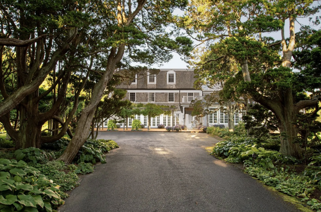 A photography of the driveway leading to the Southampton home of Roy Lichtenstein, lined with trees.