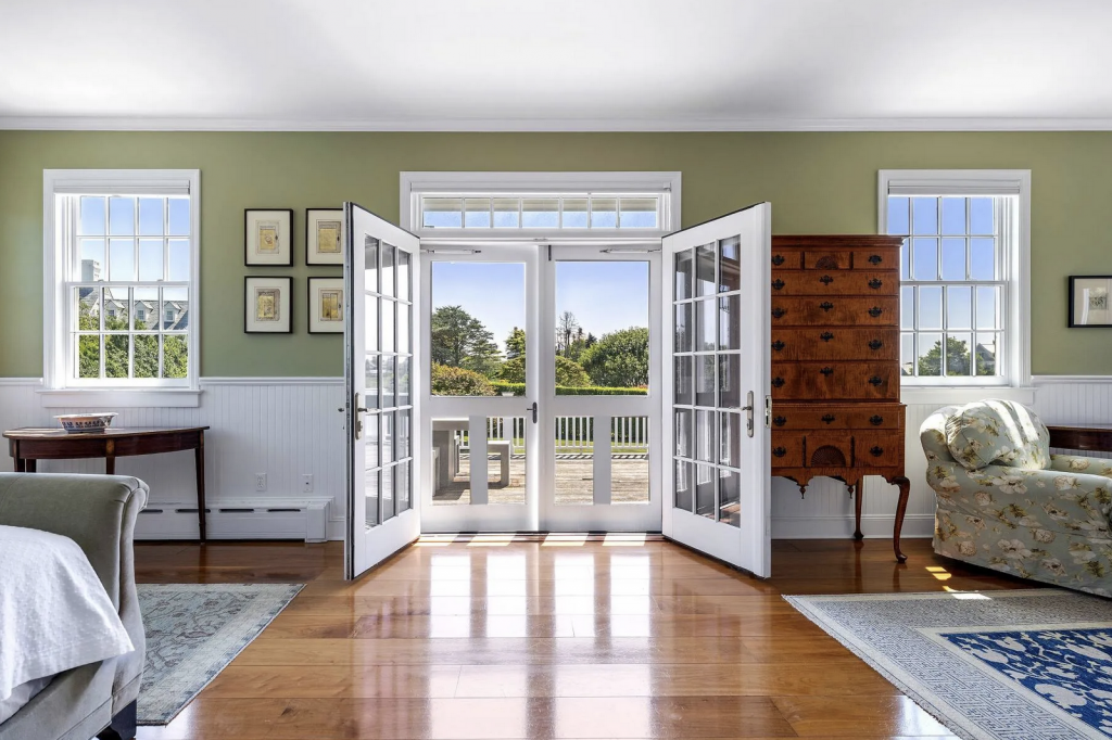 A photograph of French doors opening from a tasteful master suite out onto a balcony.