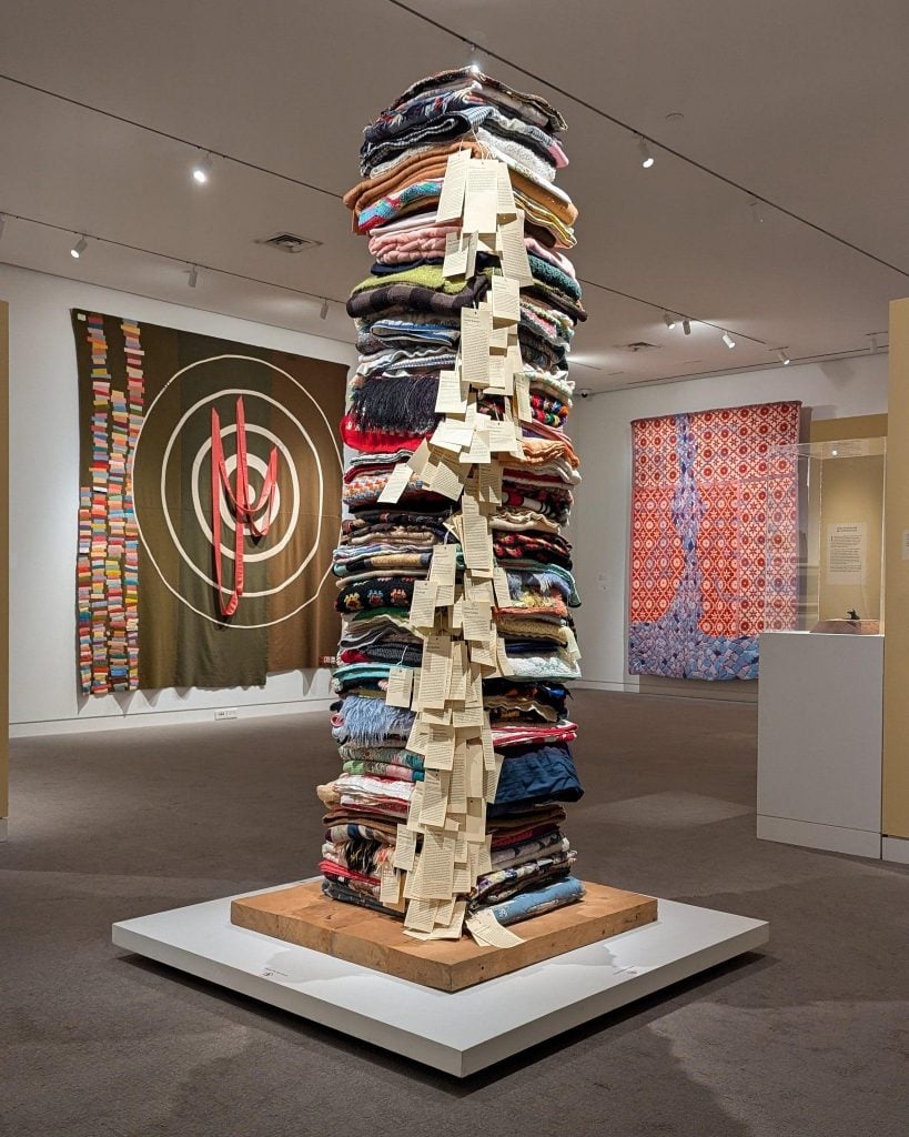 A tower of blankets in an art gallery