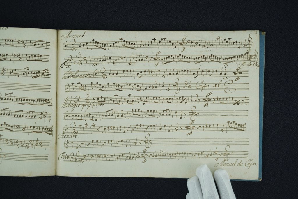 A manuscript open to reveal two pages of musical transcription