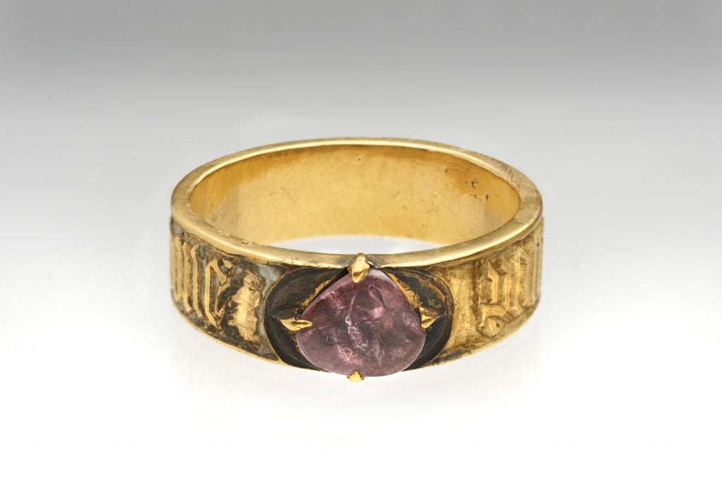 A gold finger ring with a pink genstone