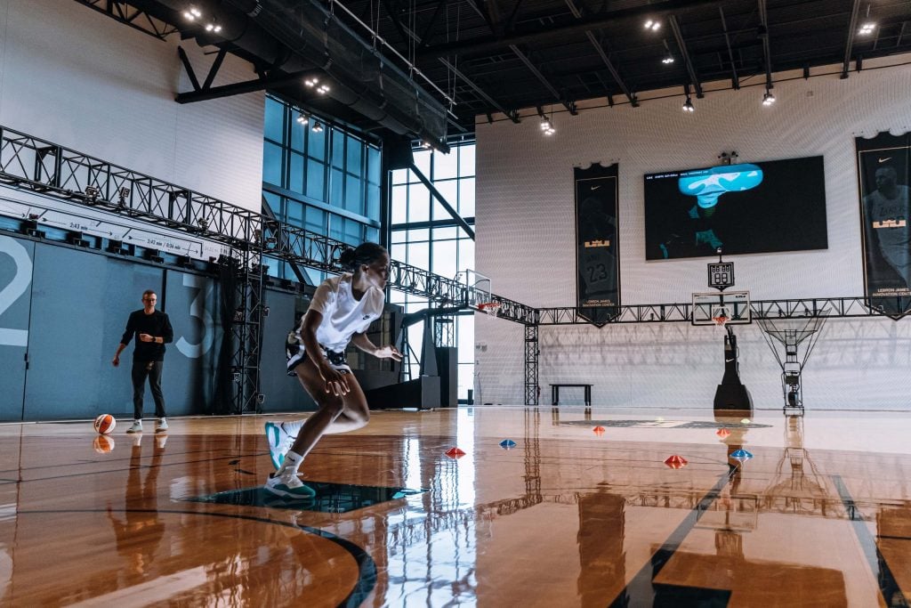 Athlete exercises on a basketball court with high-tech equipment