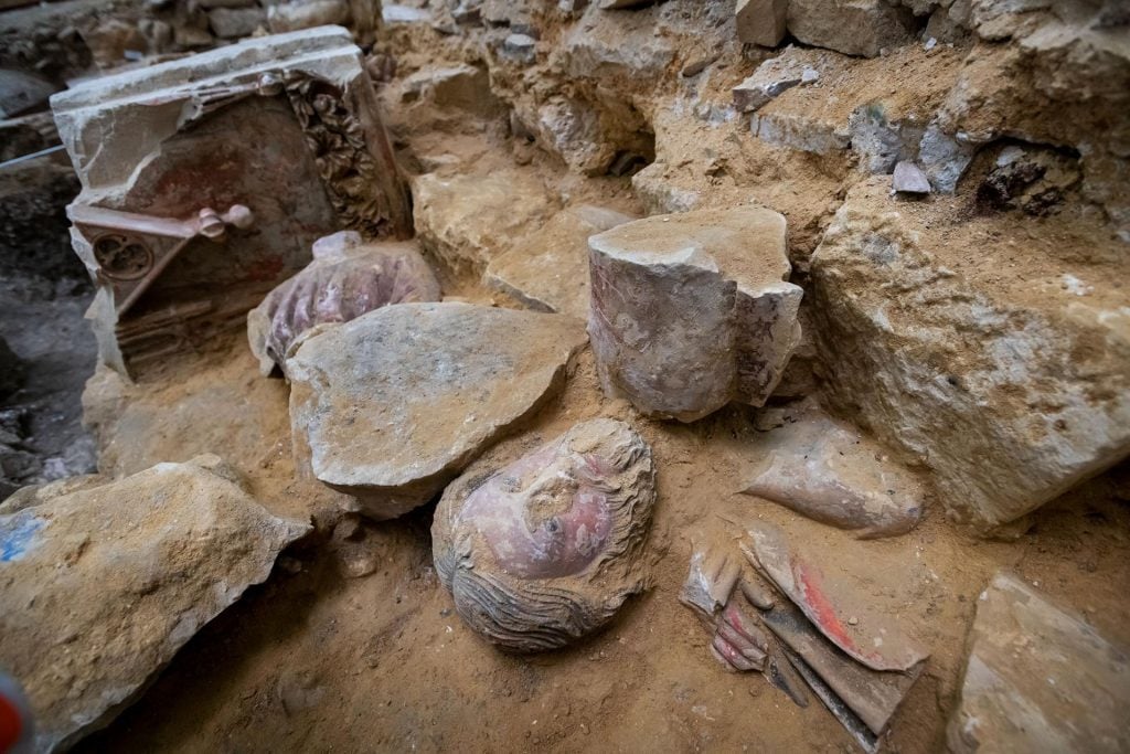 Various rocks and sculptural blocks emerging from a dusty ground