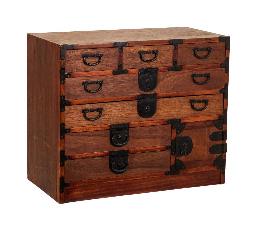 A photogaph of a wooden chest of draws with black handles from the show Friends depicted on an all-white background.